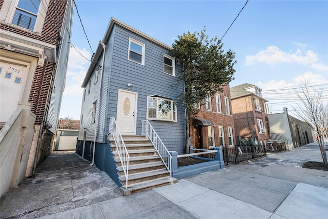 view of front of home with entry steps and fence