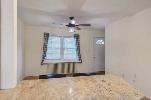 interior space featuring a ceiling fan and radiator heating unit