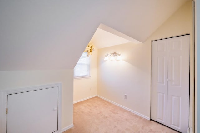 additional living space featuring lofted ceiling, light carpet, and baseboards