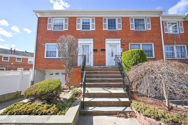 62-57 Douglaston Pkwy, Little Neck, NY 11362 - view of front of property with brick siding, an attached garage, and fence