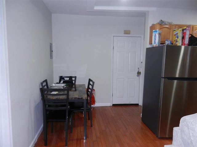 dining space with wood-type flooring and baseboards