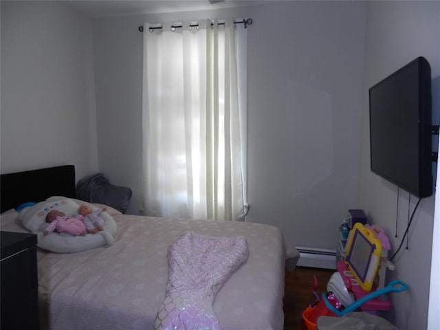 bedroom featuring multiple windows and a baseboard heating unit