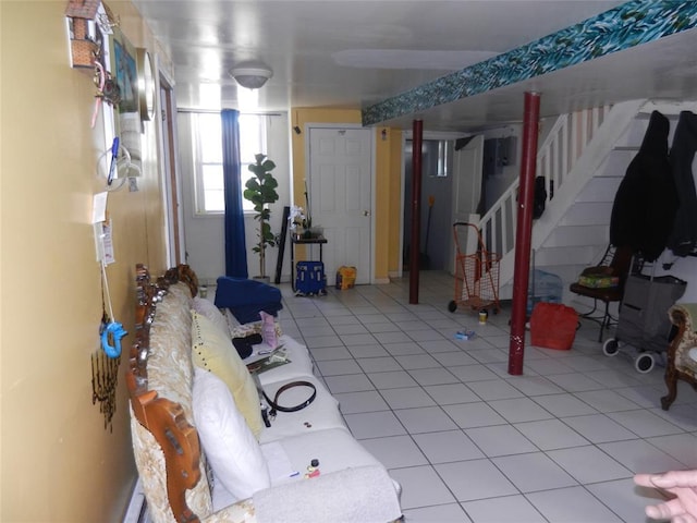 basement featuring stairway and light tile patterned flooring