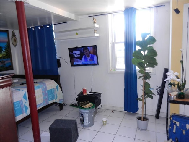 bedroom featuring tile patterned flooring and beamed ceiling