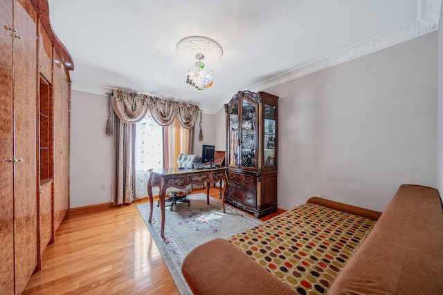 office area featuring light wood-type flooring, baseboards, a chandelier, and crown molding