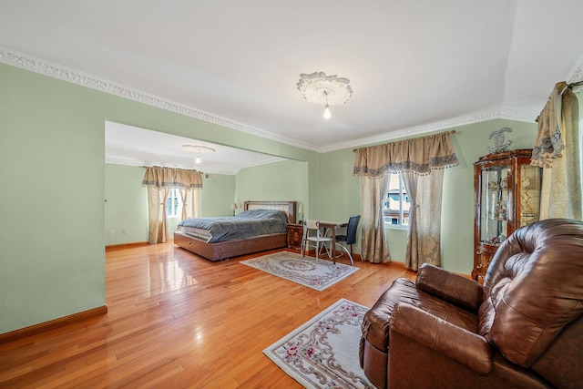 bedroom featuring crown molding, baseboards, and hardwood / wood-style flooring