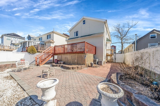 rear view of property with a fenced backyard, a residential view, stairs, a wooden deck, and a patio area