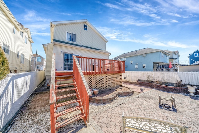 back of property with a patio area, a fenced backyard, a wooden deck, and stairs