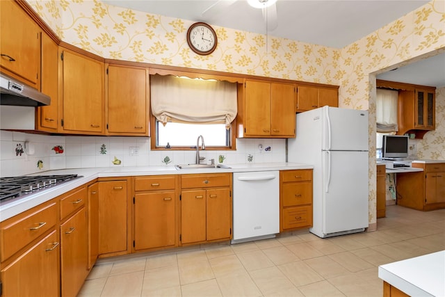 kitchen featuring wallpapered walls, under cabinet range hood, white appliances, and a sink