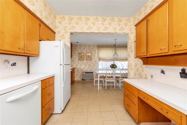 kitchen with brown cabinetry, white appliances, light countertops, and wallpapered walls