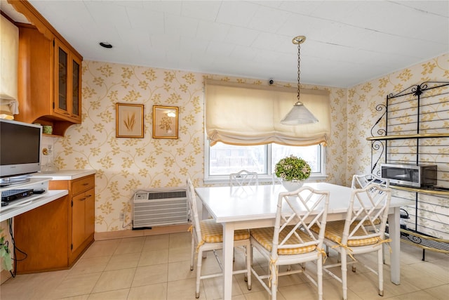 dining space with an AC wall unit, light tile patterned flooring, and wallpapered walls