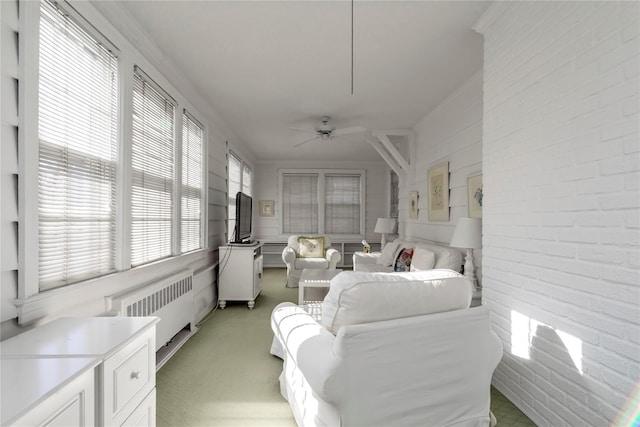 sunroom / solarium with radiator heating unit and a ceiling fan