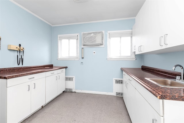 kitchen with crown molding, dark countertops, visible vents, radiator heating unit, and a sink