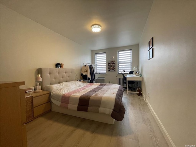 bedroom featuring light wood-style floors and baseboards