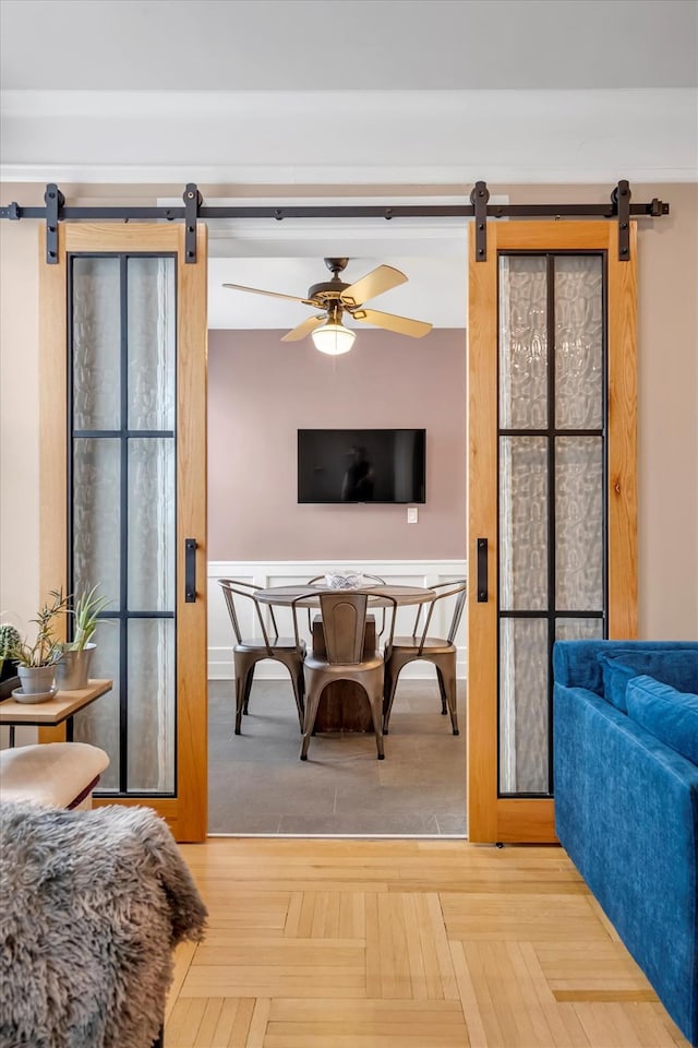 interior space with a barn door and a ceiling fan