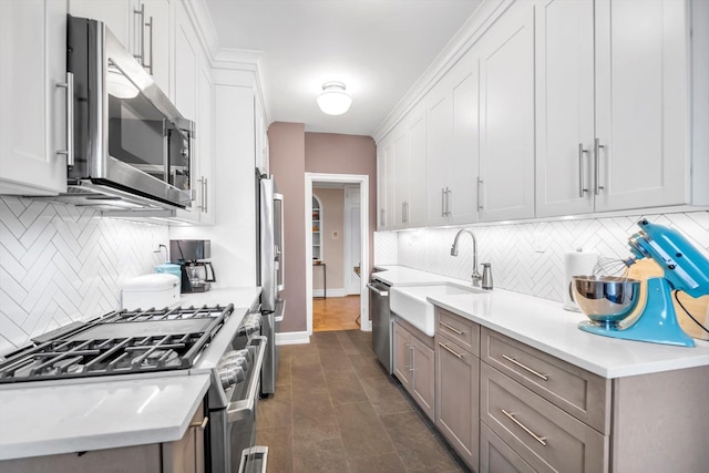 kitchen featuring stainless steel appliances, a sink, and light countertops