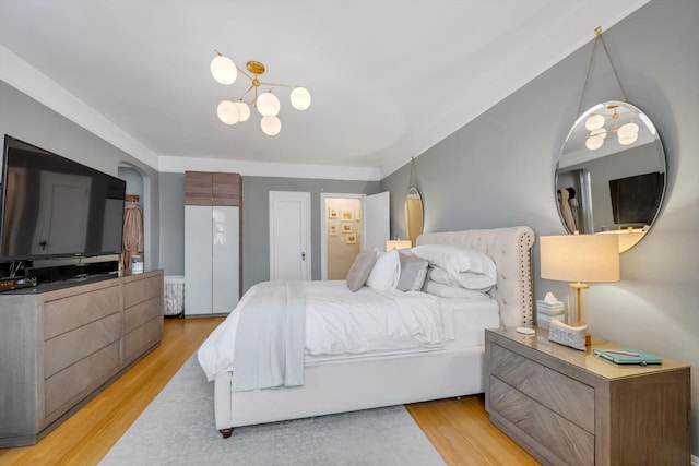 bedroom featuring a chandelier and light wood-style flooring