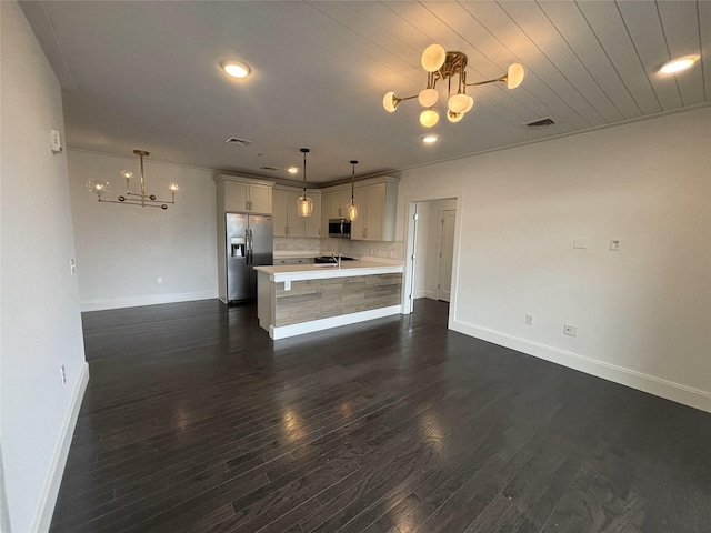 kitchen with visible vents, open floor plan, stainless steel appliances, light countertops, and a chandelier