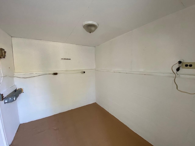 interior space featuring concrete block wall and concrete flooring