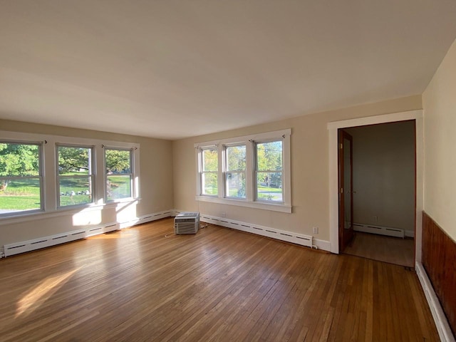 unfurnished room featuring a baseboard radiator and hardwood / wood-style floors