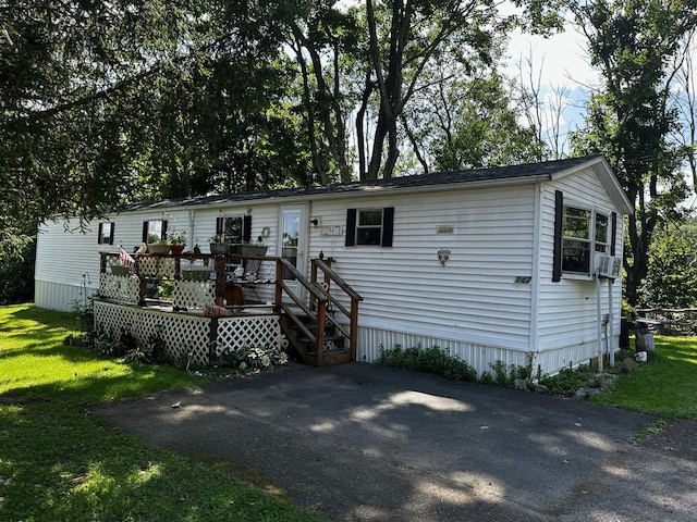 manufactured / mobile home with a deck and a front lawn