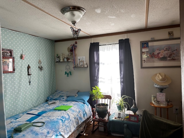 bedroom with a textured ceiling and wood finished floors