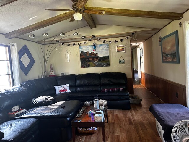 living room with a ceiling fan, wainscoting, lofted ceiling with beams, and wood finished floors