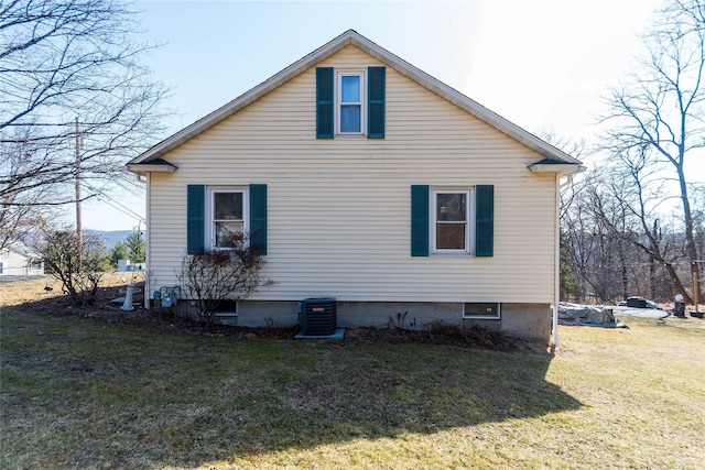 view of side of home featuring a lawn and central AC