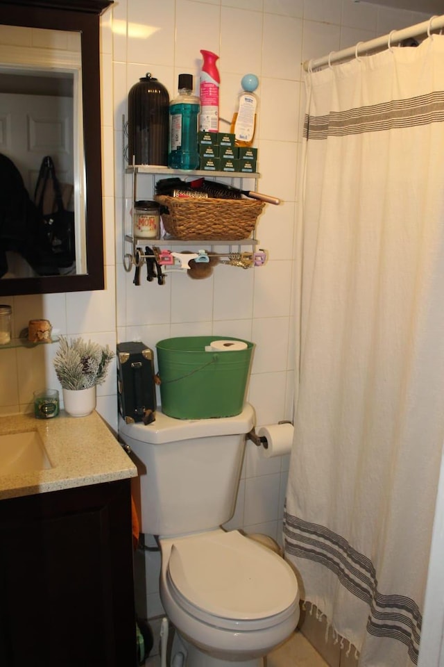 bathroom with vanity, tile walls, curtained shower, and toilet