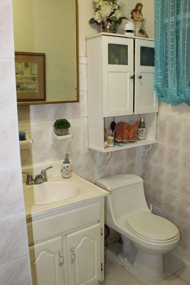 bathroom with tile patterned flooring, toilet, vanity, and tile walls