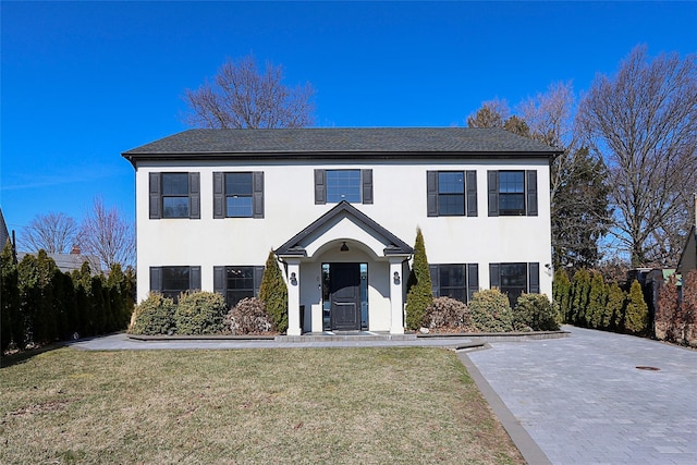 view of front of home with stucco siding and a front yard