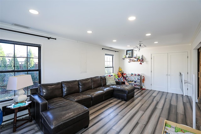 living room featuring visible vents, recessed lighting, ornamental molding, and wood finished floors