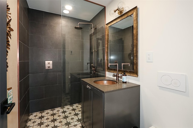 full bathroom featuring tiled shower and vanity