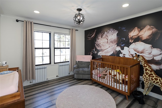 bedroom featuring wood finished floors, an inviting chandelier, ornamental molding, and radiator heating unit