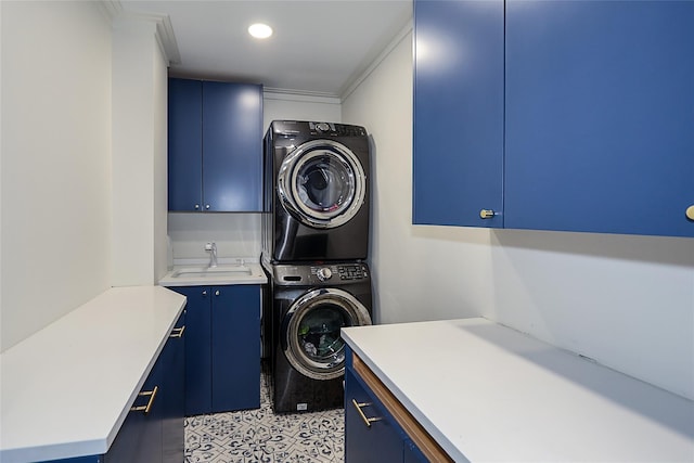 clothes washing area with a sink, cabinet space, stacked washer and clothes dryer, and recessed lighting