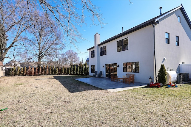 back of property with fence, central AC unit, a lawn, a chimney, and a patio