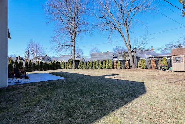 view of yard with a patio area, a shed, an outdoor structure, and fence