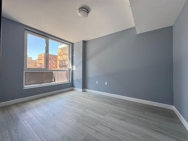 empty room featuring baseboards and wood finished floors