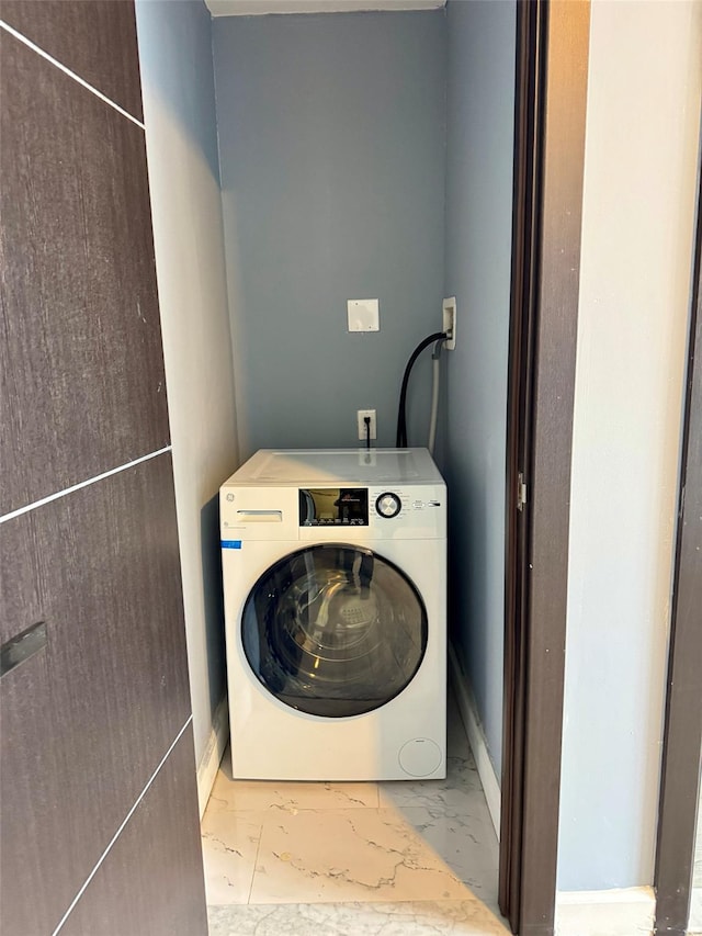 laundry area featuring washer / clothes dryer, marble finish floor, and laundry area