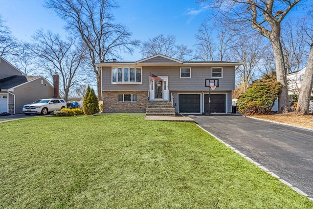 raised ranch with aphalt driveway, a front yard, and a garage