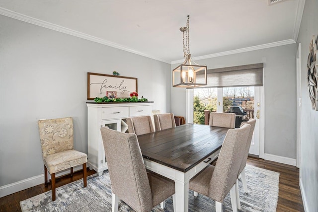 dining area with a chandelier, ornamental molding, wood finished floors, and baseboards