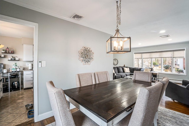 dining area with baseboards, visible vents, a chandelier, and ornamental molding