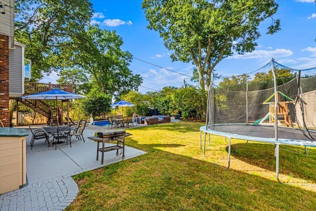 view of yard with a trampoline, outdoor lounge area, and a patio