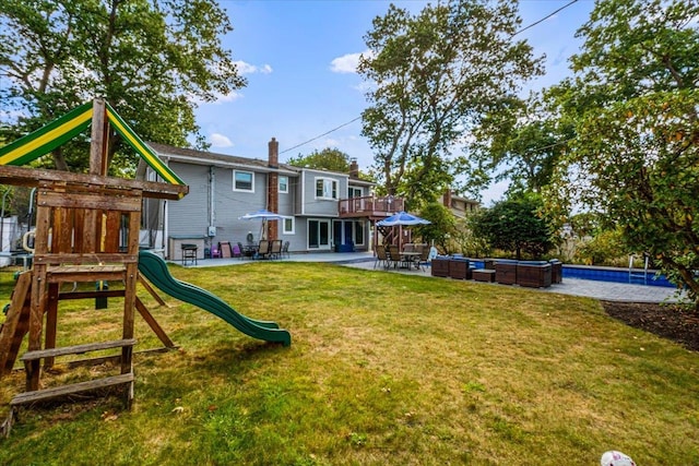 exterior space with a patio, a playground, a yard, an outdoor pool, and a chimney