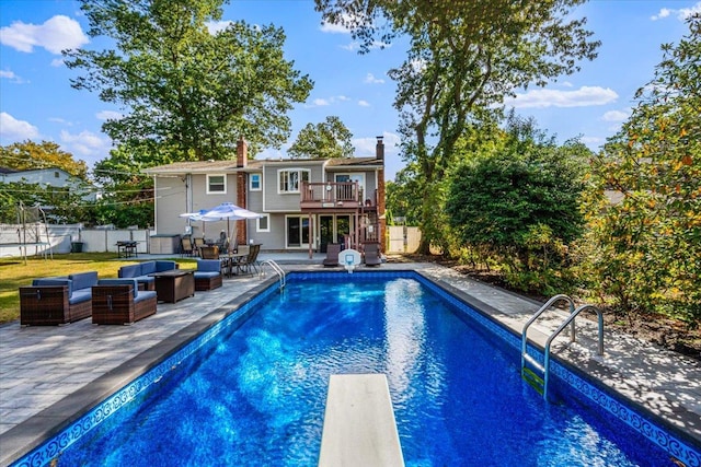 view of swimming pool with a patio area, a trampoline, fence, and an outdoor living space