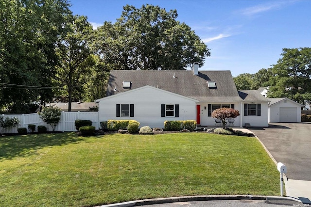 view of front of property with a garage, an outdoor structure, fence, driveway, and a front yard