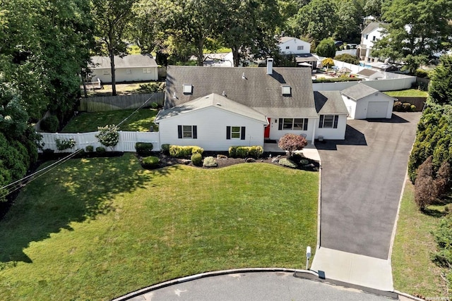 view of front of house with aphalt driveway, fence, and a front lawn