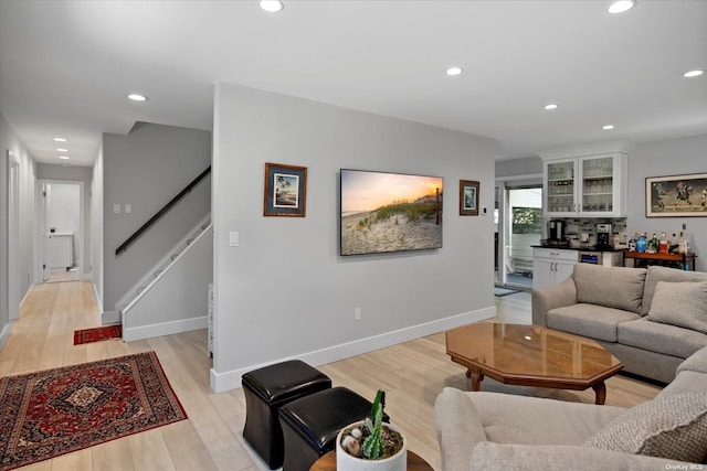 living area with light wood-style floors, baseboards, stairway, and recessed lighting