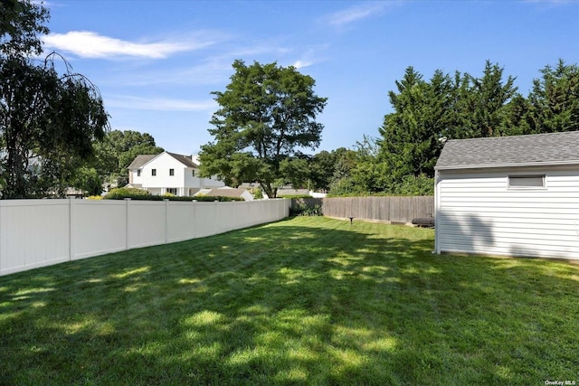 view of yard with a fenced backyard and an outdoor structure