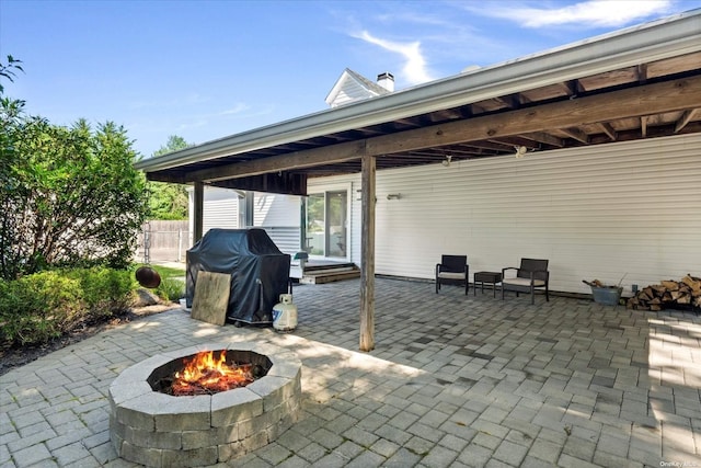 view of patio featuring a grill, fence, and a fire pit